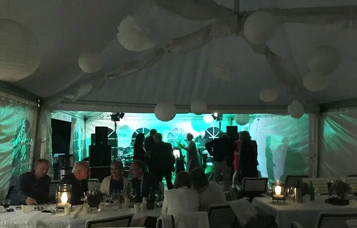 Leute richten im Zelt Tische her, stimmen Instrumente ab und besprechen gemeinsam den Ablauf für das Event.