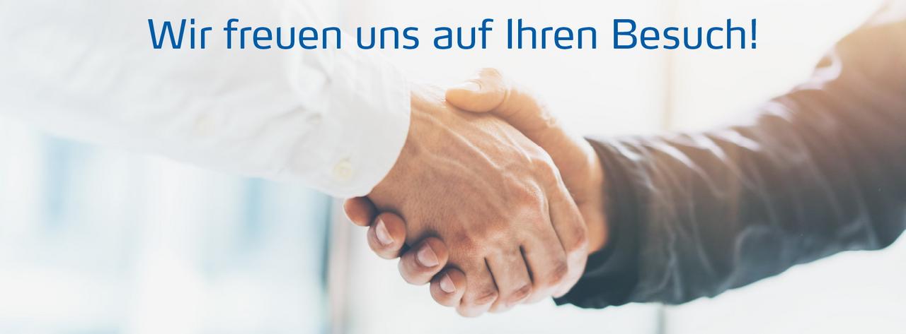 Zwei Menschen geben sich die Hand, darüber steht: Wir freuen uns auf Ihren Besuch!.